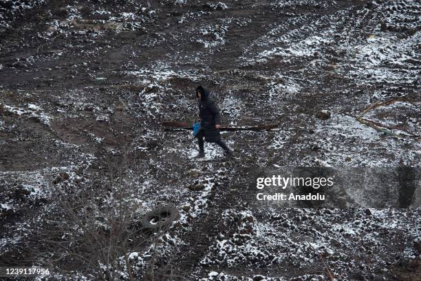 Civilian carries a bucket in the pro-Russian separatists-controlled Donetsk, Ukraine on March 11, 2022. Troops patrolled the areas in the Donetsk...