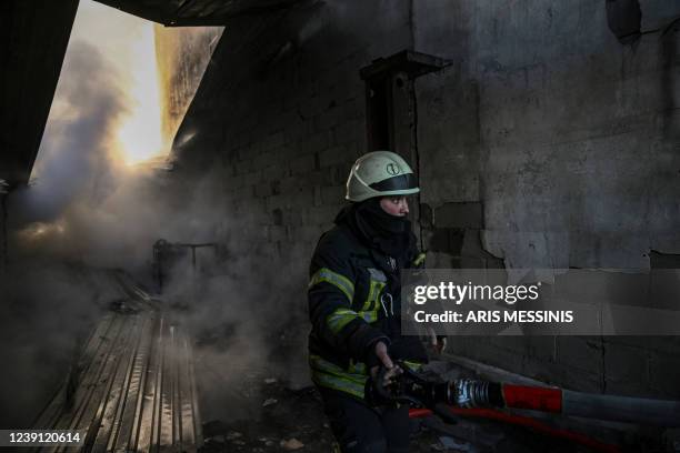 Firefighter extinguishes a fire on a building after shelling on the 17th day of the Russian invasion of Ukraine, in Kyiv on March 12, 2022. - Russian...