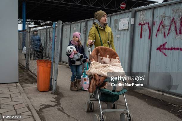 An Ukrainian mother and her daughter are seen just having cross the border and reach the city of Otaci, northern Moldova, on .