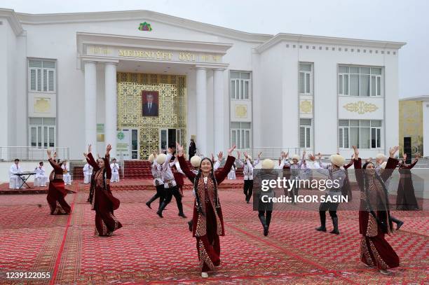 Folk artists perform in front of a polling station during the presidential election in Ashgabat on March 12, 2022. - Voting was underway in...