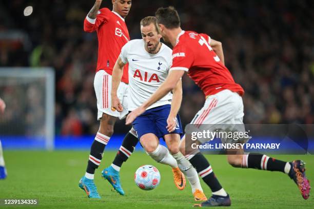 Tottenham Hotspur's English striker Harry Kane dribbles between Manchester United's English striker Marcus Rashford and Manchester United's Serbian...