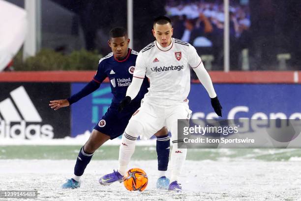 Real Salt Lake forward Bobby Wood plays the ball watched y New England Revolution midfielder Lucas Maciel Felix during a match between the New...