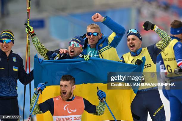 Team Ukraine celebrates at the finish line during the open relay para cross-country skiing event on March 13 at the Zhangjiakou National Biathlon...