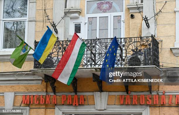 This photograph taken on March 7, 2022 shows Ukrainian, Hungarian and European flags displayed on the town hall of Berehove, western Ukraine....