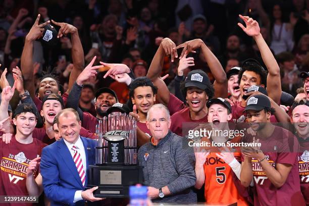Commissione Jim Phillips hands the Championship Trophy to Virginia Tech Hokies head coach Mike Young after winning the ACC Tournament final college...