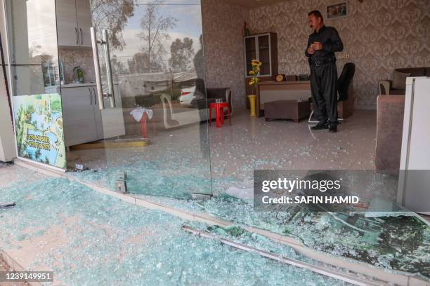 Man inspects the damage at a shop following an overnight attack in Arbil, the capital of the northern Iraqi Kurdish autonomous region on March 13,...