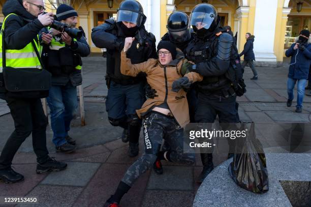 Police officers detain a man during a protest against Russian military action in Ukraine, in central Saint Petersburg on March 13, 2022.