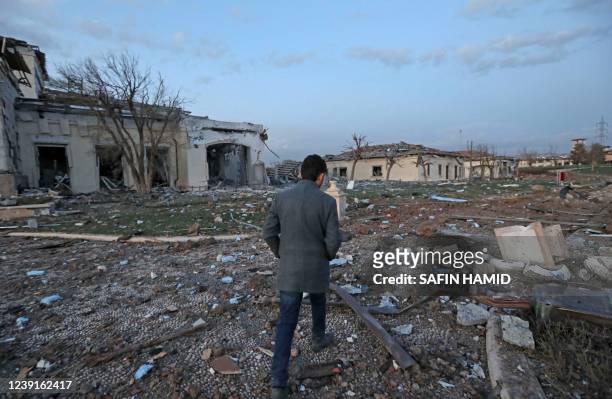 Man walks past damaged mansions following an overnight attack in Arbil, the capital of the northern Iraqi Kurdish autonomous region, on March 13,...