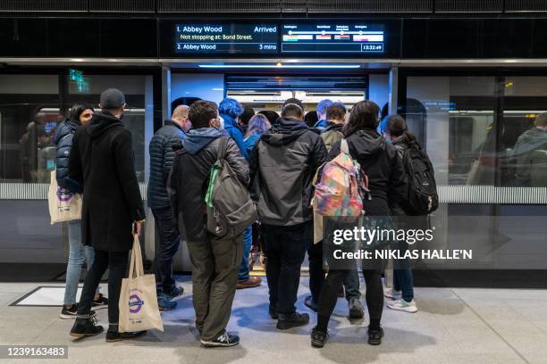 Volunteer 'passengers' board a carriage during a test run of a Transport for London Elizabeth Line train between Paddington station and Woolwich...