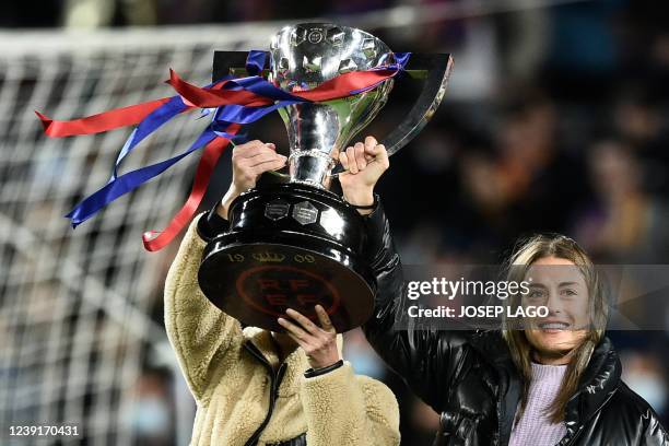 Barcelona's Alexia Putellas holds up a trophy as she celebrates with teammates their Spanish Liga title, before the start of the Spanish league...