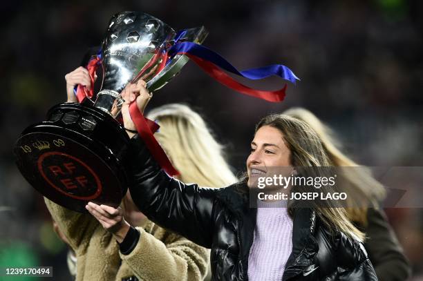 Barcelona's Alexia Putellas holds up a trophy as she celebrates with teammates their Spanish Liga title, before the start of the Spanish league...