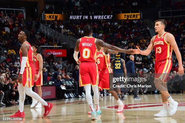 Delon Wright high fives Bogdan Bogdanovic of the Atlanta Hawks during the game against the Indiana Pacers on March 13, 2022 at State Farm Arena in...