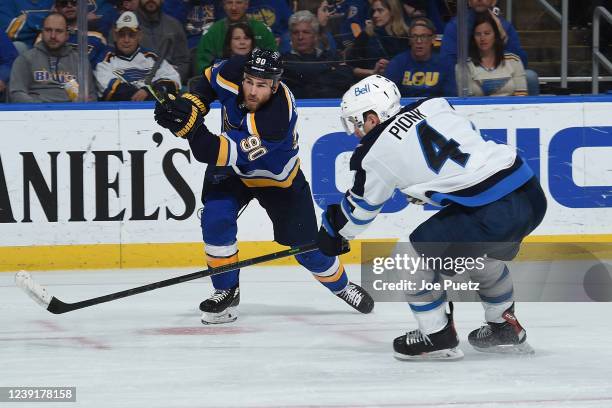 Neal Pionk of the Winnipeg Jets attempts to block a shot from Ryan O'Reilly of the St. Louis Blues at the Enterprise Center on March 13, 2022 in St....