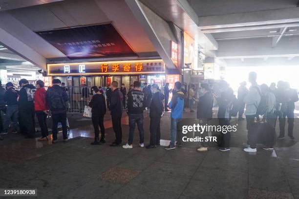 Passengers queue to undergo nucleic acid tests for the Covid-19 coronavirus at Hangzhou Railway Station in Hangzhou in China's eastern Zhejiang...