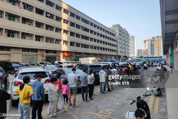 This photo taken on March 13, 2022 shows residents queueing to undergo nucleic acid tests for the Covid-19 coronavirus in Shenzhen, in China's...