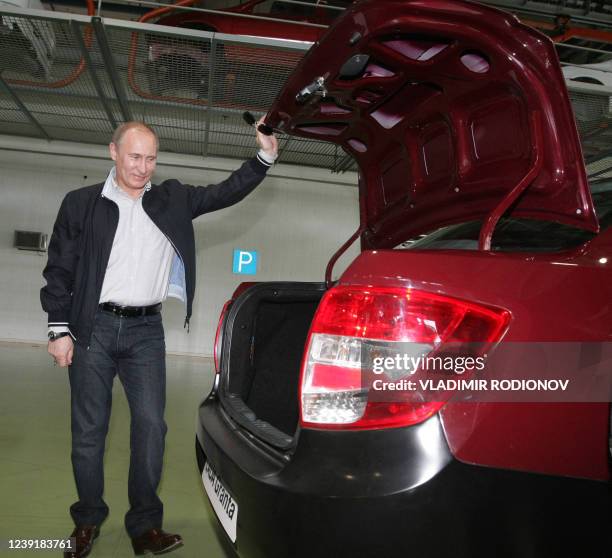 Russian Prime Minister Vladimir Putin opens a boot of a new model of Russian Lada-Granta car during his visist to "AvtoVaz" automobile plant in...