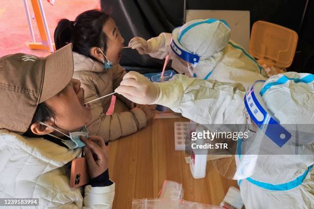 Residents undergo nucleic acid tests for the Covid-19 coronavirus in Yantai, in China's eastern Shandong province on March 14, 2022. - China OUT /...