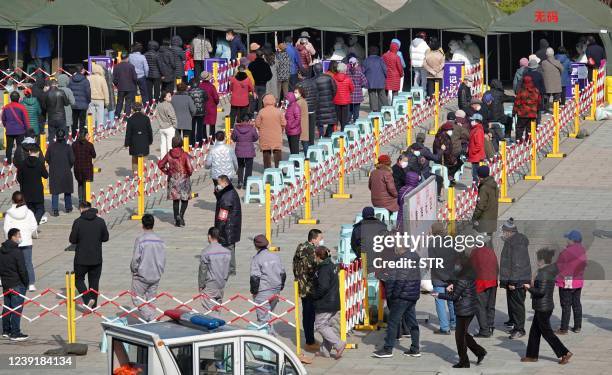 Residents queue to undergo nucleic acid tests for the Covid-19 coronavirus in Yantai, in China's eastern Shandong province on March 14, 2022. - China...