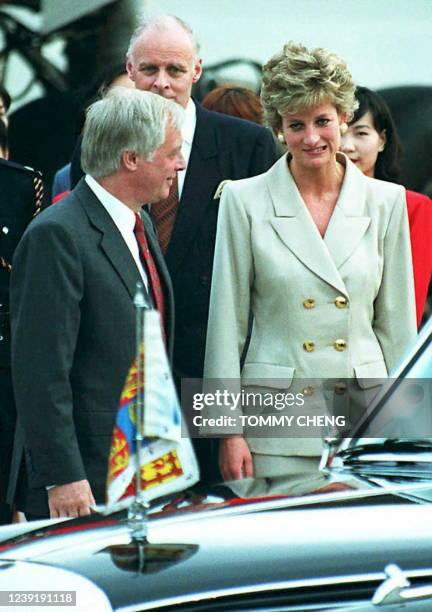 The Princess of Wales makes a face in the direction of the media covering her arrival in Hong Kong 21 April after Hong Kong Governor Chris Patten...