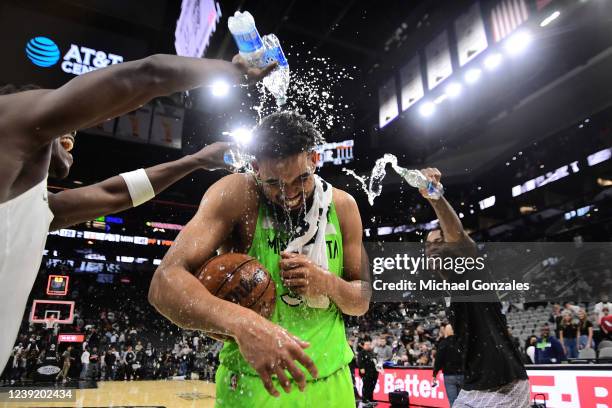 Anthony Edwards and Jarred Vanderbilt pour water on Karl-Anthony Towns of the Minnesota Timberwolves after the game against the San Antonio Spurs on...