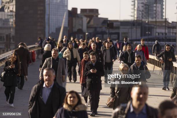 Morning commuters cross London Bridge in the City of London, U.K. On Monday, March 14, 2022. U.K. Unemployment dropped below its pre-pandemic level...