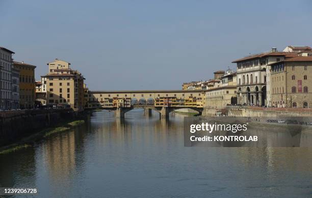 View the famous historic Ponte Vecchio bridge a medieval stone closed-spandrel segmental arch bridge over the Arno River.