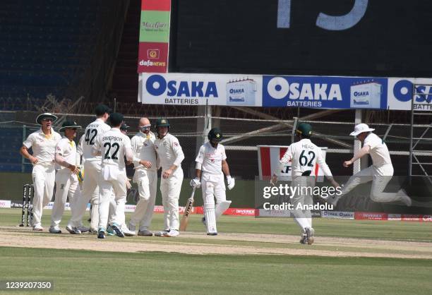 Australia's celebrates with teammates after taking the wicket of Imam-ul-Haq during the fourth day of the second test match between Pakistan and...