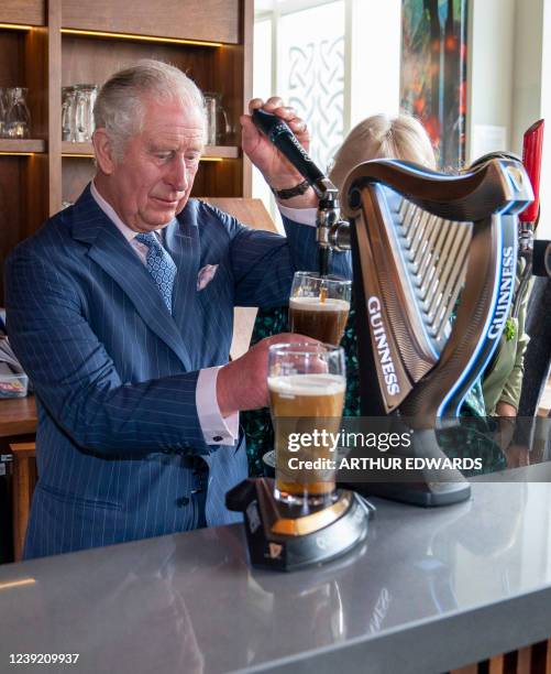 Britain's Prince Charles, Prince of Wales pours a pint of Guinness during a visit to the Irish Cultural Centre in London on March 15 to celebrate the...