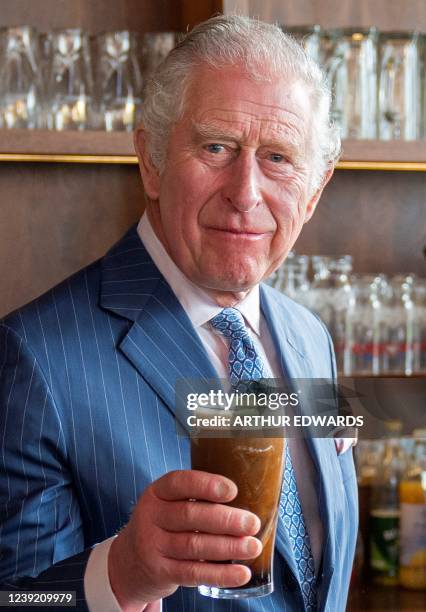 Britain's Prince Charles, Prince of Wales poses with a pint of Guinness that he poured, during a visit to the Irish Cultural Centre in London on...