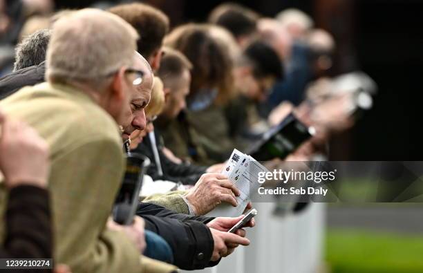 Gloucestershire , United Kingdom - 15 March 2022; Racegoers study the form before racing on day one of the Cheltenham Racing Festival at Prestbury...