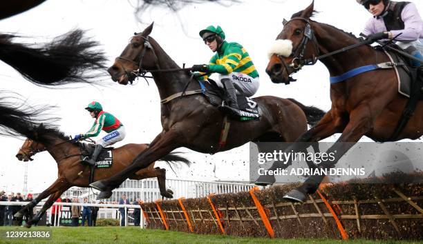 Jockey Tom Scudamore on Adagio and jockey Mark Walsh on Saint Roi jump a hurdle during the Champion Hurdle on the first day of the Cheltenham...