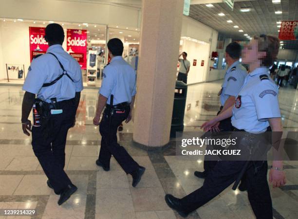 Des policiers de proximité du commissariat de Noisy-Le-Grand patrouillent dans un centre commercial de la ville, le 19 juillet 2002, dans le cadre de...