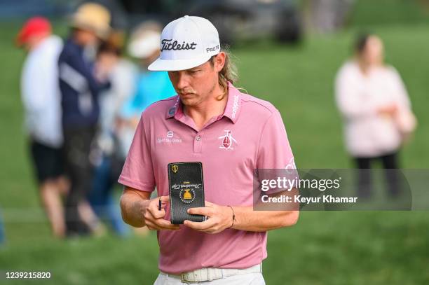 Cameron Smith of Australia holds his yardage book showing the Presidents Cup International Team logo after making a par putt on the 15th hole green...