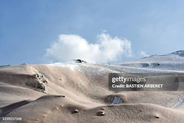 This photograph taken on March 15, 2022 shows sand from Sahara that fell overnight covering the snow, in Piau-Engaly ski ressort, southern France. -...