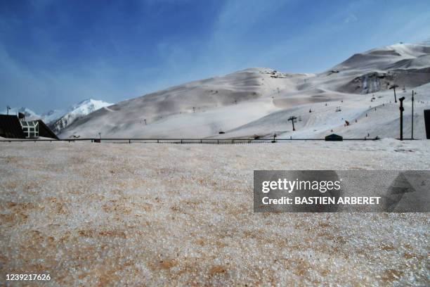 This photograph taken on March 15, 2022 shows sand from Sahara that fell overnight covering the snow, in Piau-Engaly ski ressort, southern France. -...