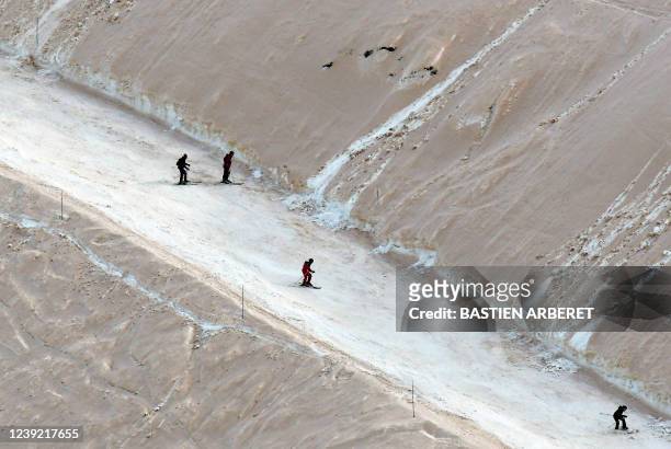 Skiers go down as sand from Sahara felt overnight covering the snow, in Piau-Engaly ski ressort, southwestern France, on March 15, 2022. - Orange...