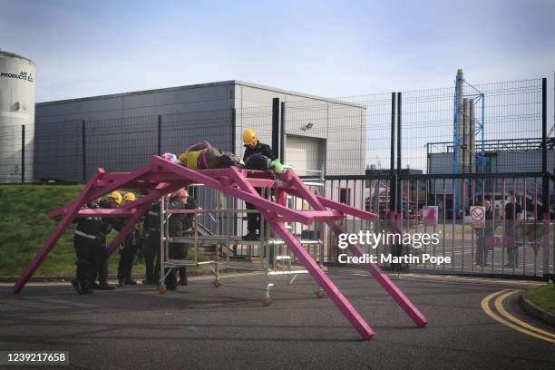 Police inspect an activist that is locked on to a Da Vinci bridge by a d-lock and chain around his neck on March 15, 2022 in Cambridge, England. XR...