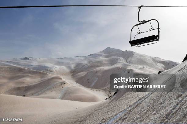 This photograph taken on March 15, 2022 shows sand from Sahara that fell overnight covering the snow, in Piau-Engaly ski ressort, southern France. -...