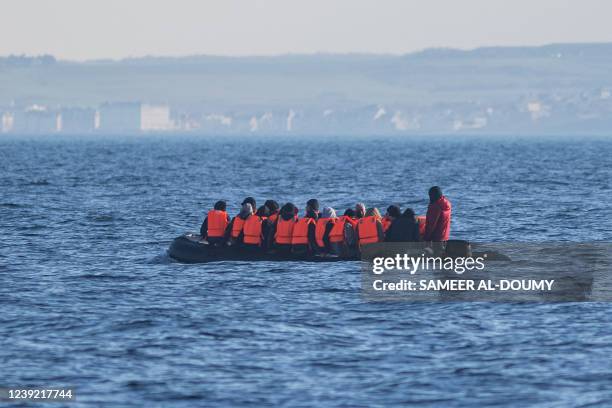 Migrants wearing life jackets sit in a dinghy as they illegally cross the English Channel from France to Britain on March 15, 2022.