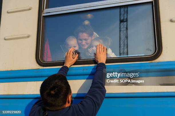 Man gestures to his family outside a train to Poland at Lviv Railway station amid Russian invasion to Ukraine. Lviv, the largest city in western...