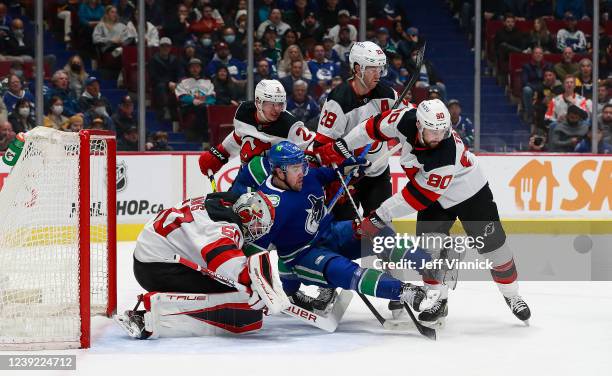 Nico Daws of the New Jersey Devils looks on as teammates Colton White, Damon Severson, and Tomas Tatar check Tanner Pearson of the Vancouver Canucks...