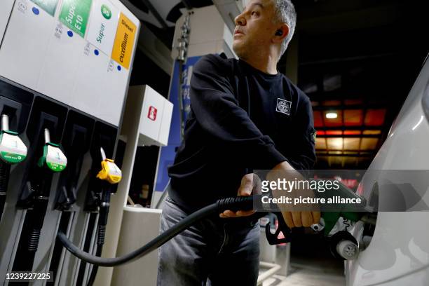 March 2022, Berlin: A cab driver fills up his vehicle with gasoline at a gas station. Fuel prices have been stagnating at a very high level for...