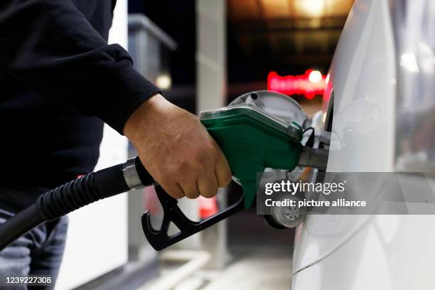 March 2022, Berlin: A cab driver fills up his vehicle with gasoline at a gas station. Fuel prices have been stagnating at a very high level for...