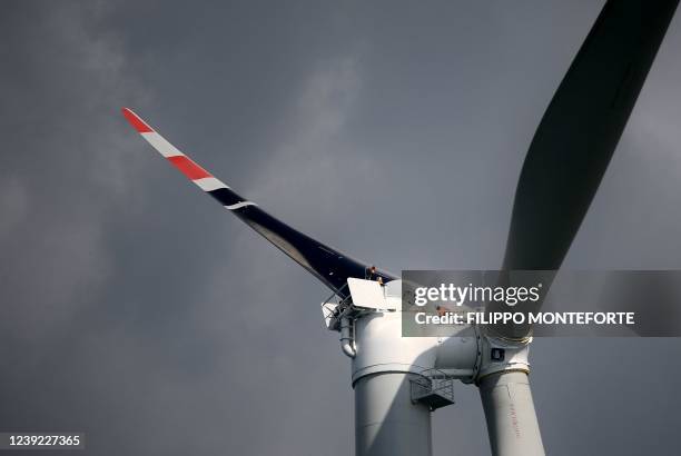 Worker stands atop a wind turbine during its assembly at the Taranto offshore wind turbines farm on March 10, 2022 in Taranto, southern Italy. - The...