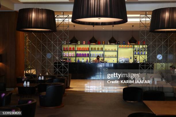 An employee stands behind the bar at a cafe at the Marriott Marquis hotel in the Qatari capital Doha on March 15, 2022. - Fans have sought 17 million...