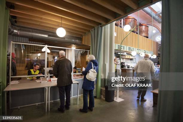 People cast their ballots in the Wispe Brewery on the third day of the municipal elections, in Weesp on March 16, 2022. - Residents of Weesp or...