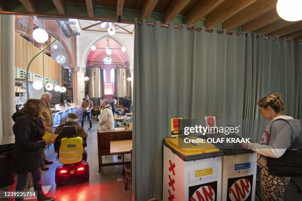 People cast their ballots in the Wispe Brewery on the third day of the municipal elections, in Weesp on March 16, 2022. - Residents of Weesp or...