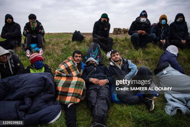 Migrants wait for a bus in Calais, north of France, on March 16 to go back to their makeshift camps after a failed crossing attempt.