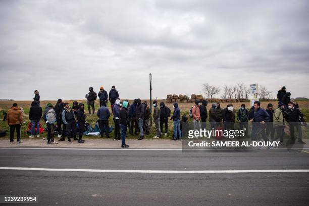 Migrants wait for a bus in Calais, north of France, on March 16 to go back to their makeshift camps after a failed crossing attempt.