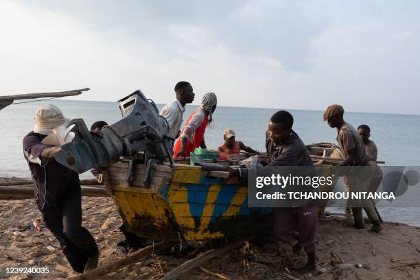 Burundian fisherman move their fishing boat onto the beach after fishing overnight at Lake Tanganyika in Bujumbura, Burundi, on March 16, 2022.